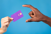 Closeup view of young woman giving credit card to African American man on blue, a Photo by Prostock-Studio (Thumbnail 1 of 2)