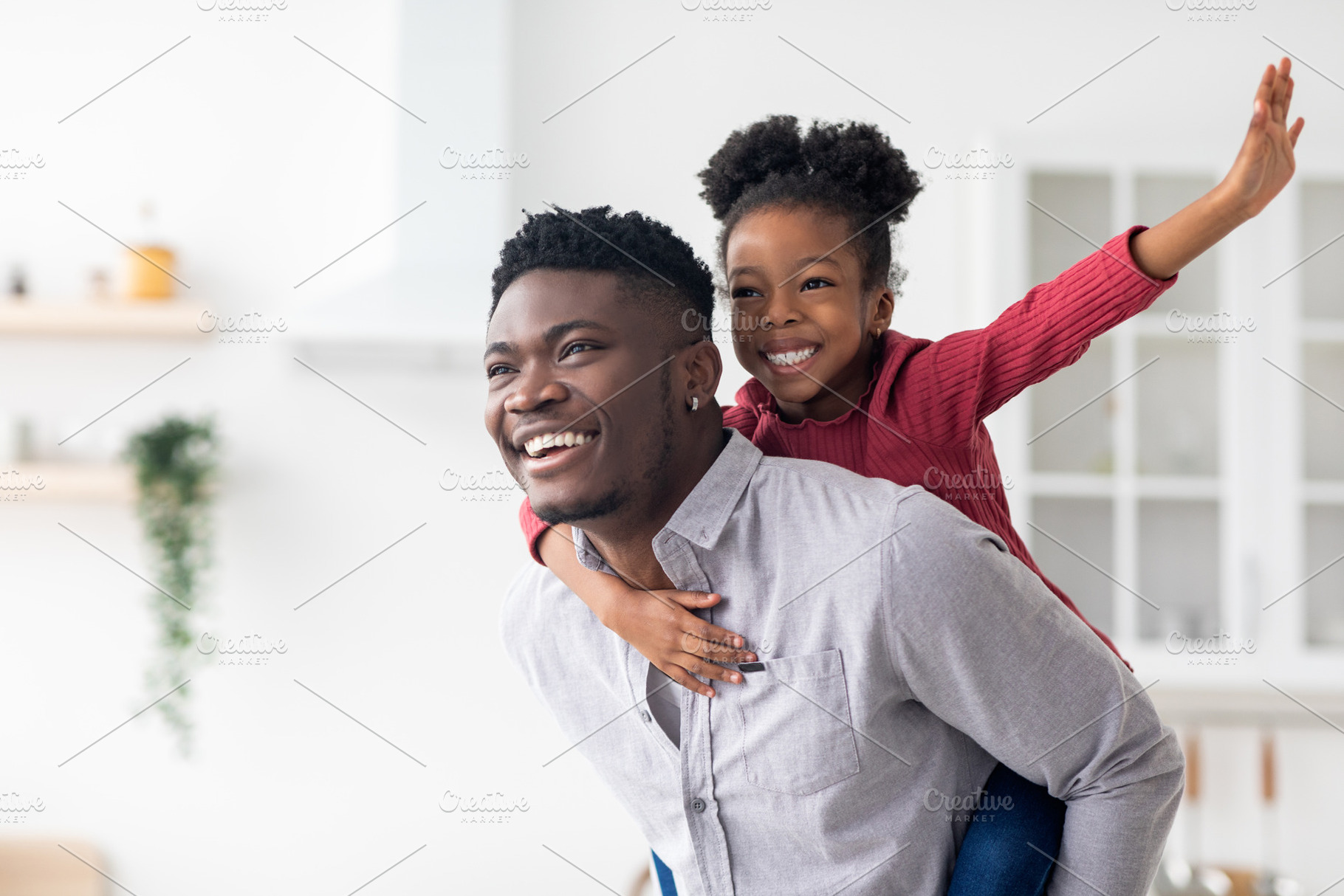 Happy black father piggybacking his pretty little daughter, a Photo by Prostock-Studio