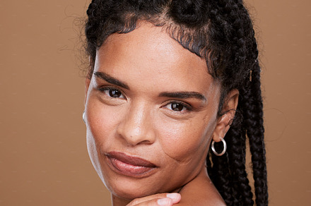 Woman, beauty and portrait of black woman with braids for skincare, facial treatment and health or wellness. Beautiful female, luxury skin care and bodycare on a brown studio background, a Photo by Peopleimages.com