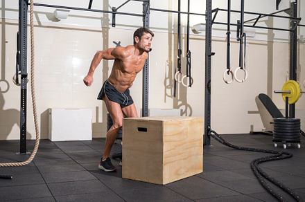 Muscular male athlete is practicing jumping on a wooden box in modern health cl, a Sports & Recreation Photo by david.herraez.calzad