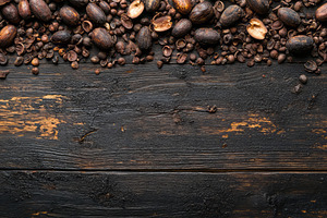A rustic wooden surface adorned with a mix of coffee beans and roasted shells,, a Background Photo by ImageMir