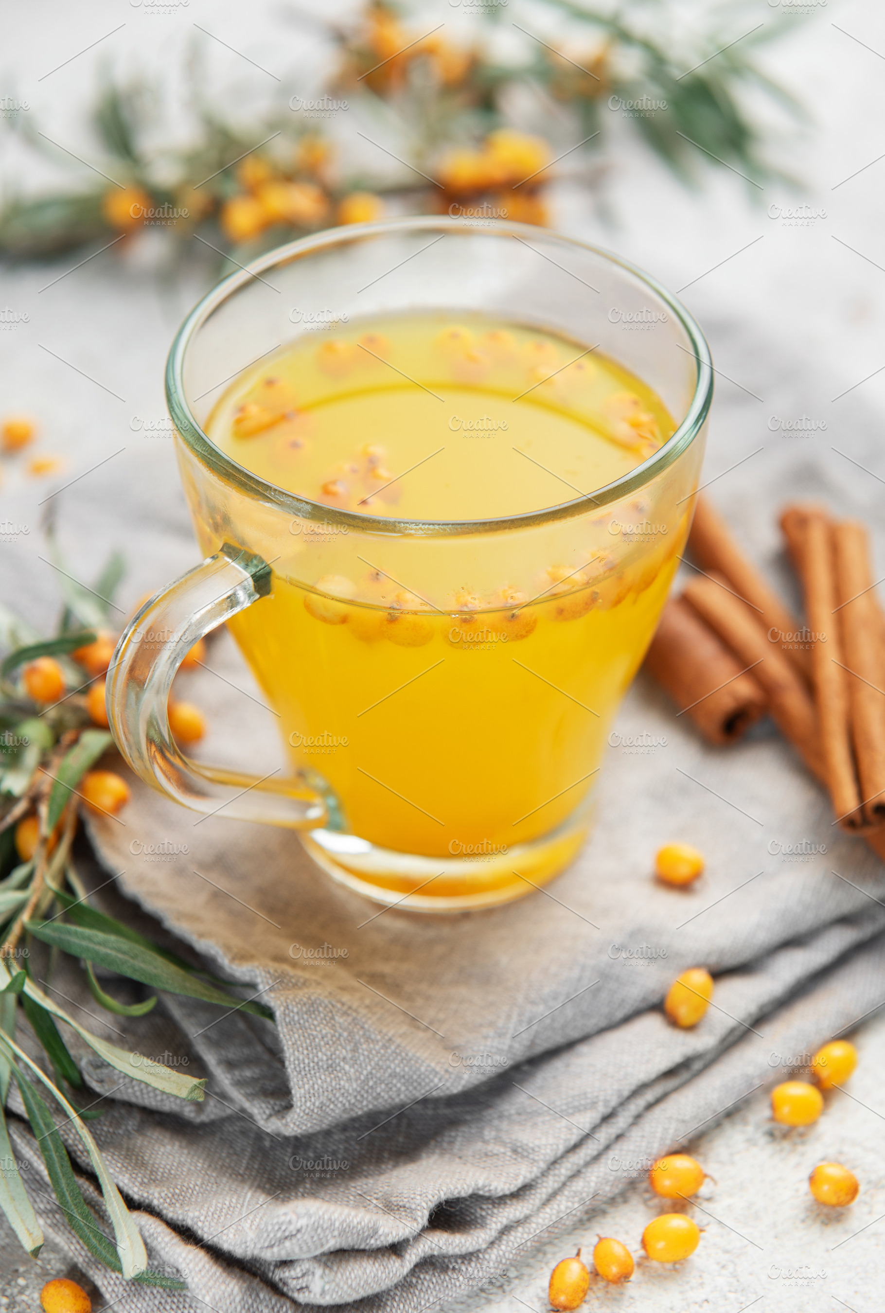 Sea buckthorn tea with berries and cinnamon sticks on grey napki, a Food & Drink Photo by Olena Rudo