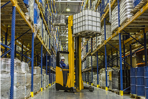 Warehouse worker on stacker taking