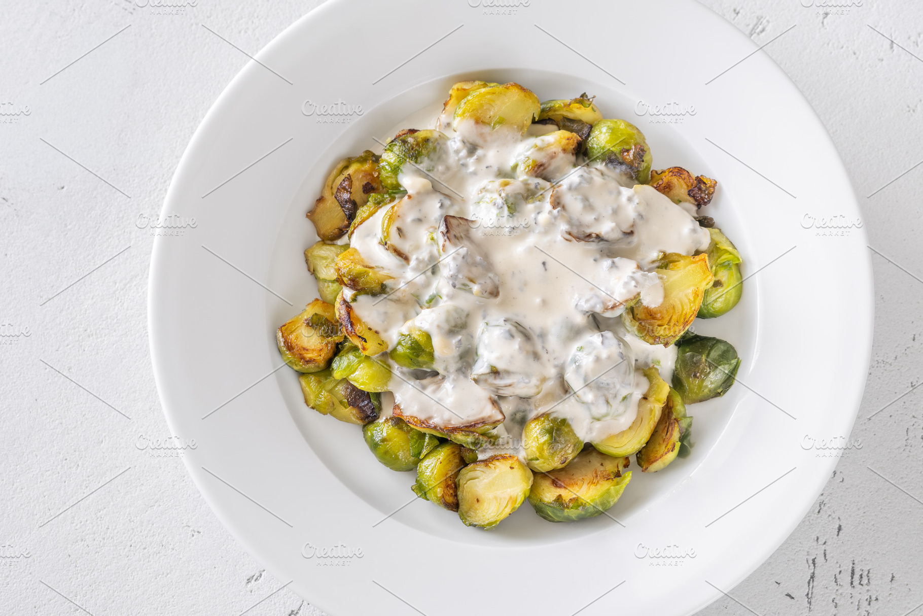 Roasted Brussels sprouts with creamy blue cheese sauce in white, a Food & Drink Photo by Alexander Prokopenko