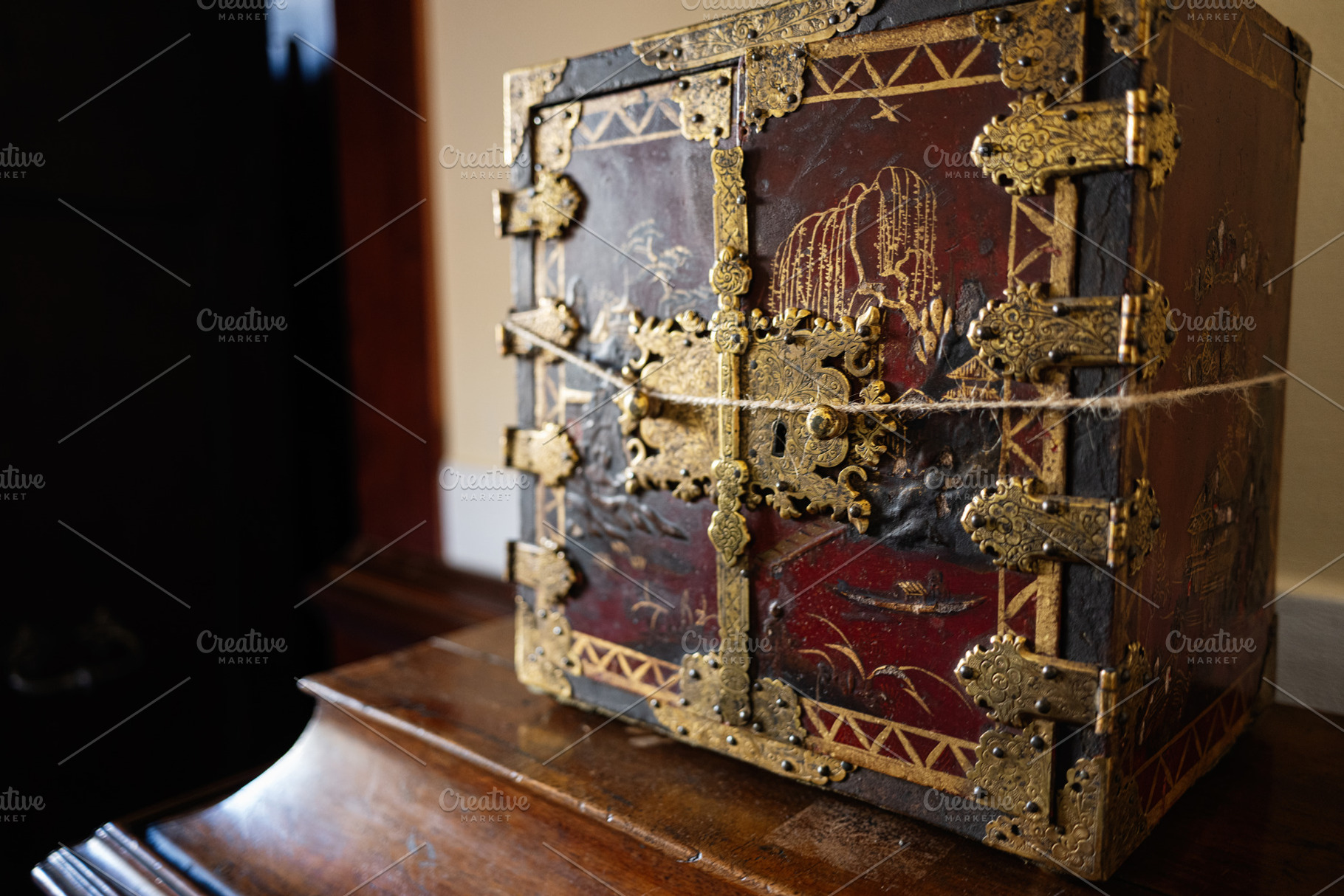 Decorative antique box with ornate details placed on wooden surface indoors, a Photo by AS photostudio