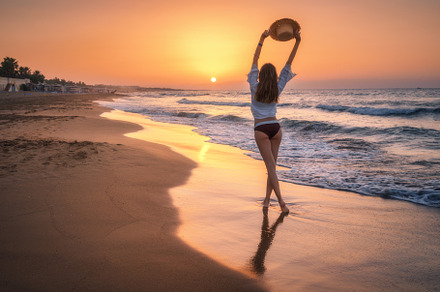 Beautiful woman with straw hat is standing in sea with waves, a Person Photo by den-belitsky