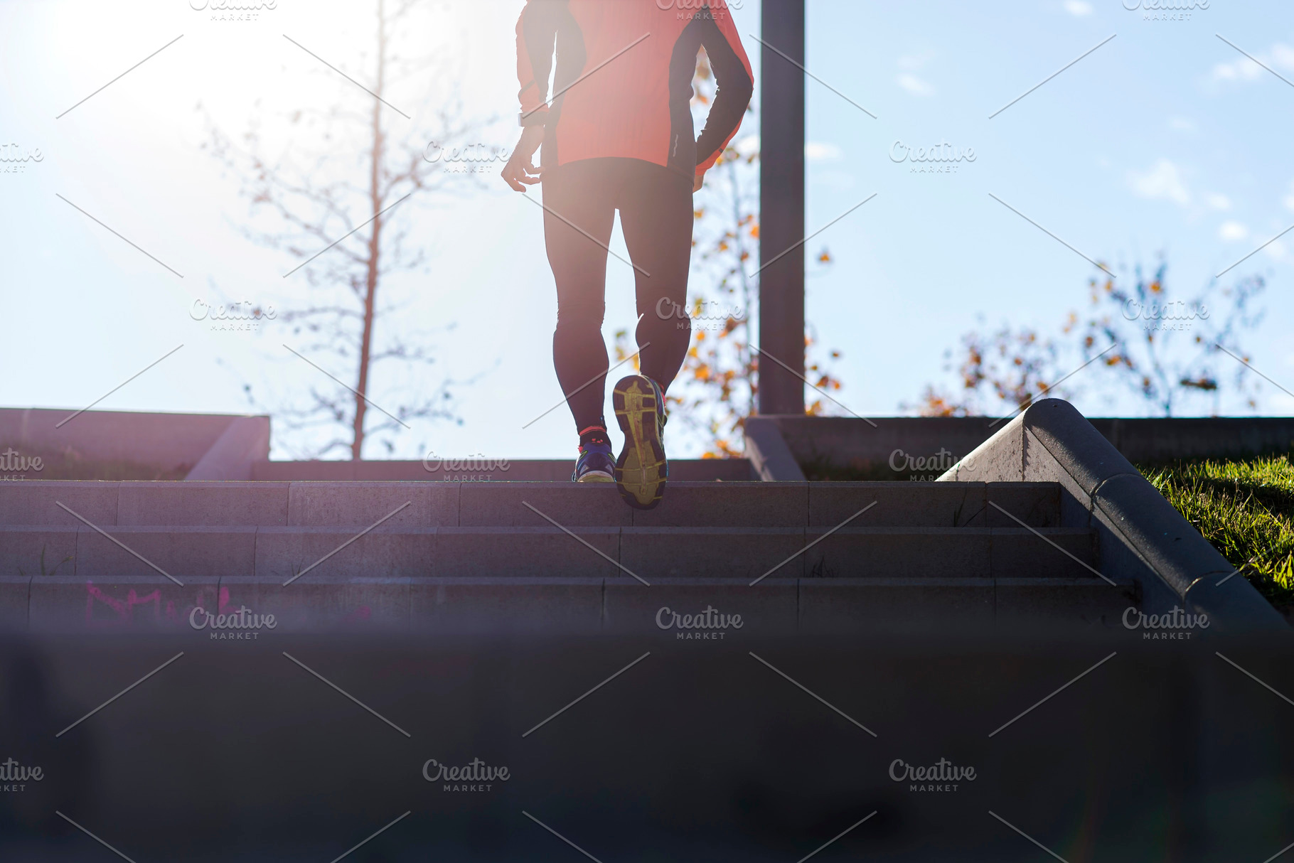 Active senior man climbing stairs in outdoor park sunlight, a Sports & Recreation Photo by RF Images