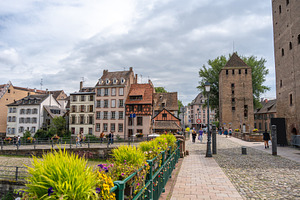 Cobblestone bridge and medieval tower in Strasbourg, France, an Architecture Photo by GoodGoods
