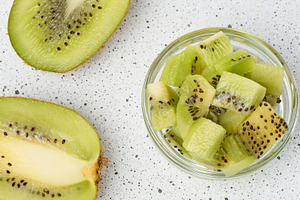 Diced kiwi in glass bowl, top view, a Food & Drink Photo by ndanko