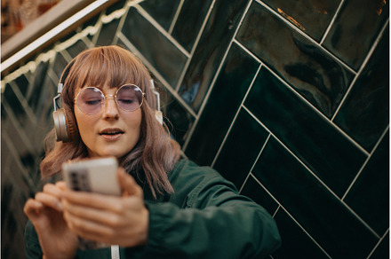 Young woman wearing headphones and, a Person Photo by HalfPoint