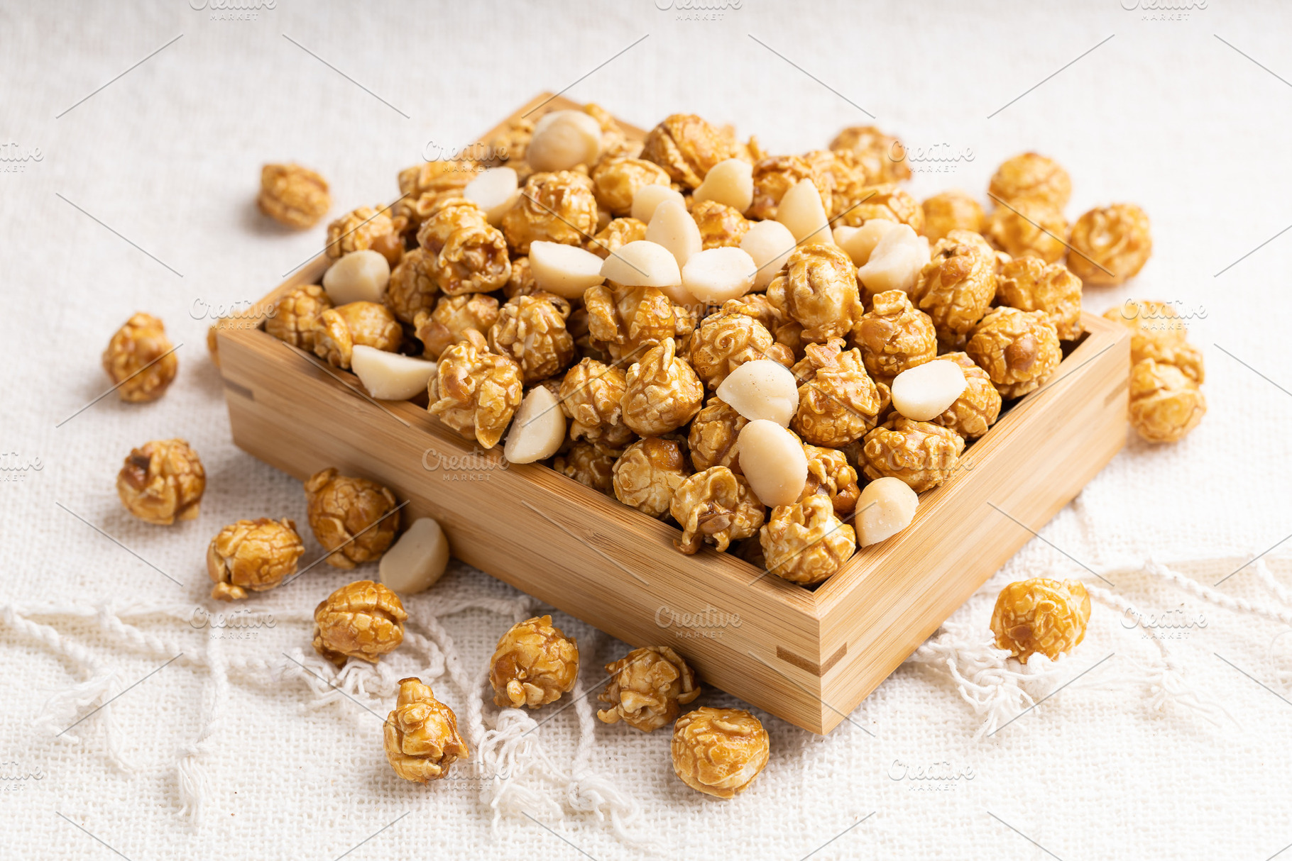 Caramel popcorn with macadamia nut in bamboo wooden box, a Food & Drink Photo by Smith Chetanachan