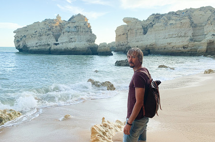 Man standing barefoot on sandy Algarve beach