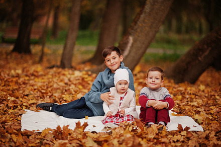Happy family of three kids at autumn leaves park., a Person Photo by AS photostudio