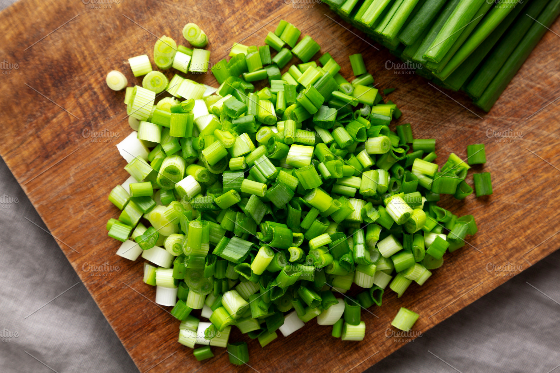 Organic Cut Green Onion Scallions on a Wooden Board, top view., a Food & Drink Photo by LiudmylaChuhunova