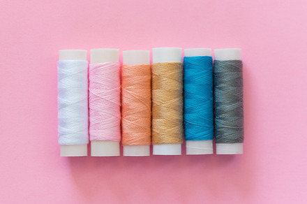 Thread spools with pink background featuring thread, spool, and embroidery