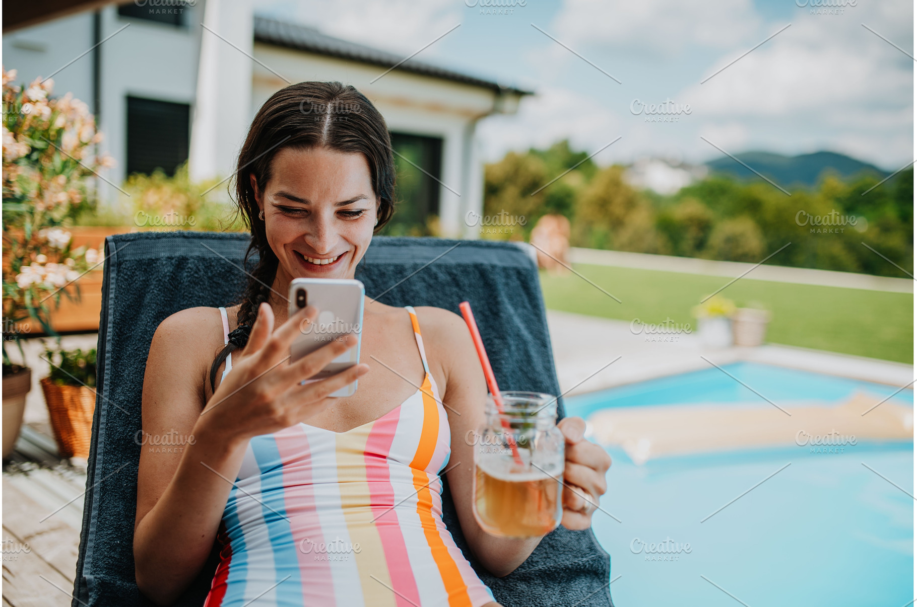 Young woman sitting by swimming pool, a Person Photo by HalfPoint