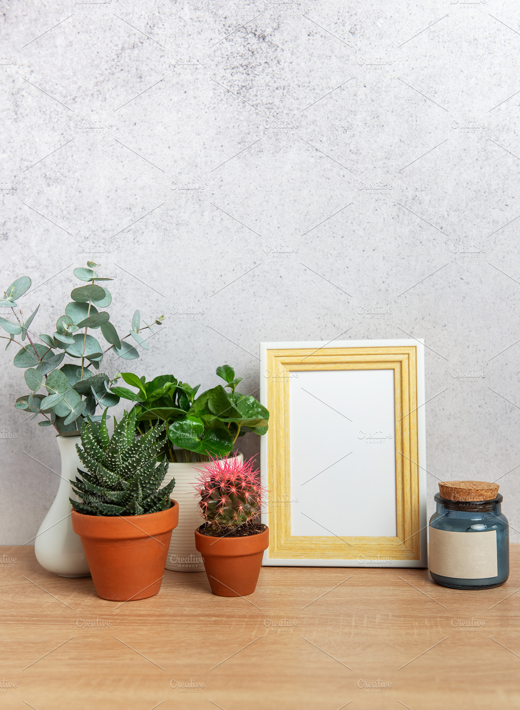 Modern home decor with blank picture frame, plants, and candle o, a Nature Photo by Olena Rudo