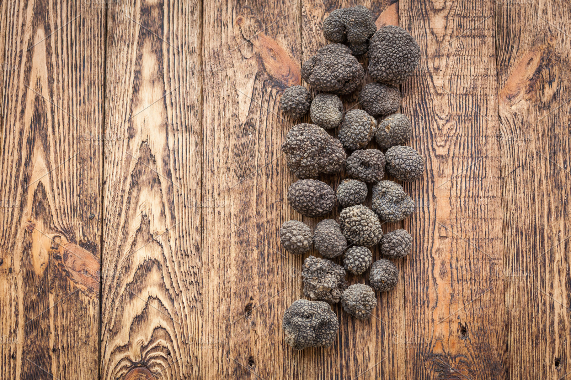 Black truffles on a wooden table top view, a Food & Drink Photo by Dolce Vita