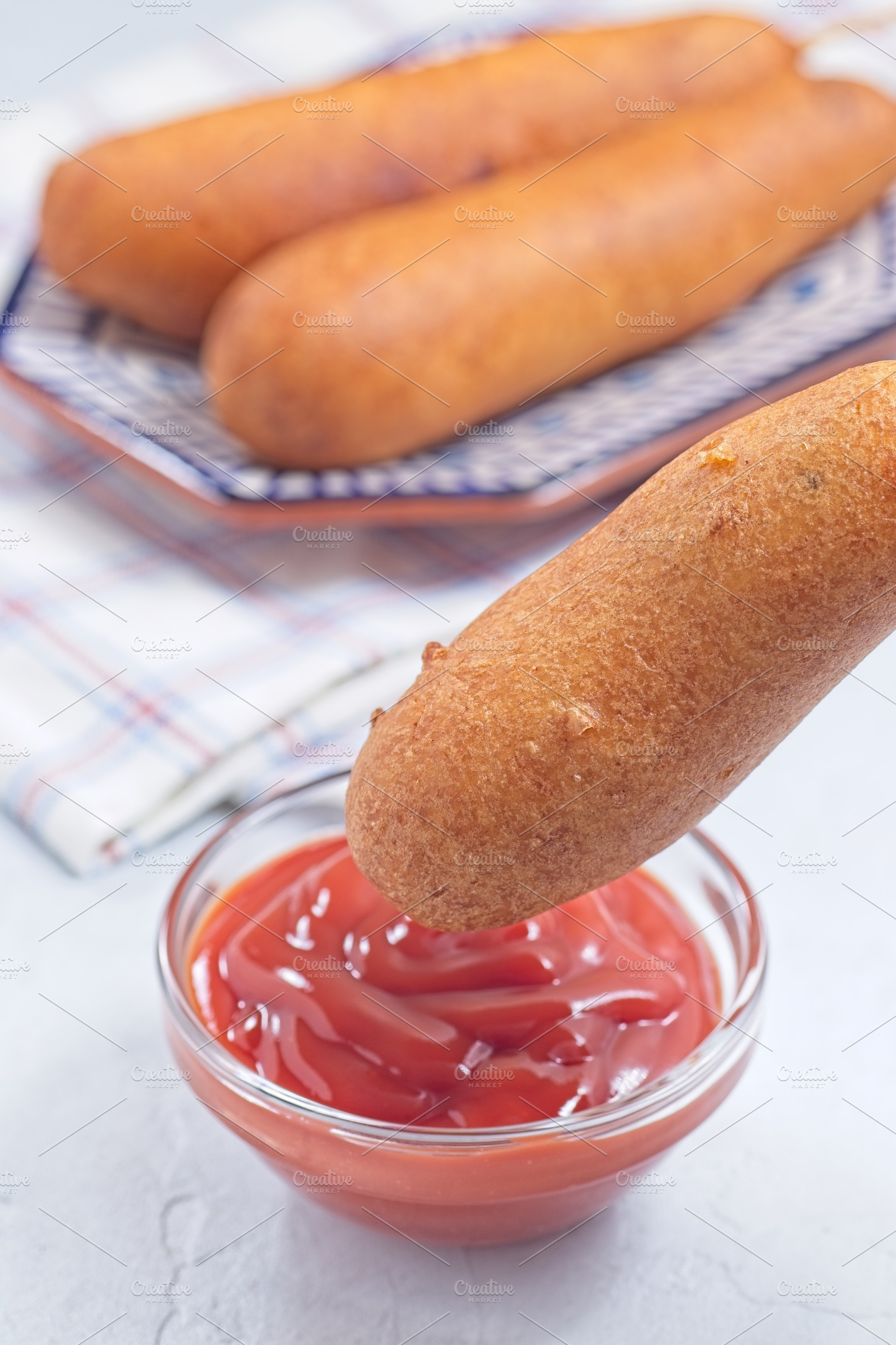 Corn dog with ketchup, vertical, a Food & Drink Photo by iuliia_n