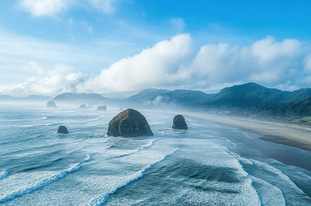 Waves crash gently on a sandy beach, a Photo by Tanuart