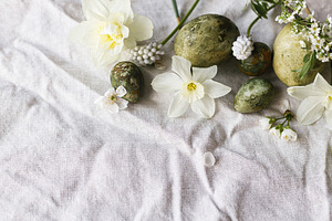 Happy Easter! Stylish natural dyed eggs and spring flowers on li, a Holiday Photo by Sonjachni
