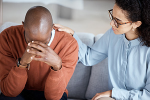 Support, therapy and woman with black man, help with grief and depression in office. Mental health, female psychologist and African American male patient with sadness, anxiety and anxious with loss, a Photo by Peopleimages.com