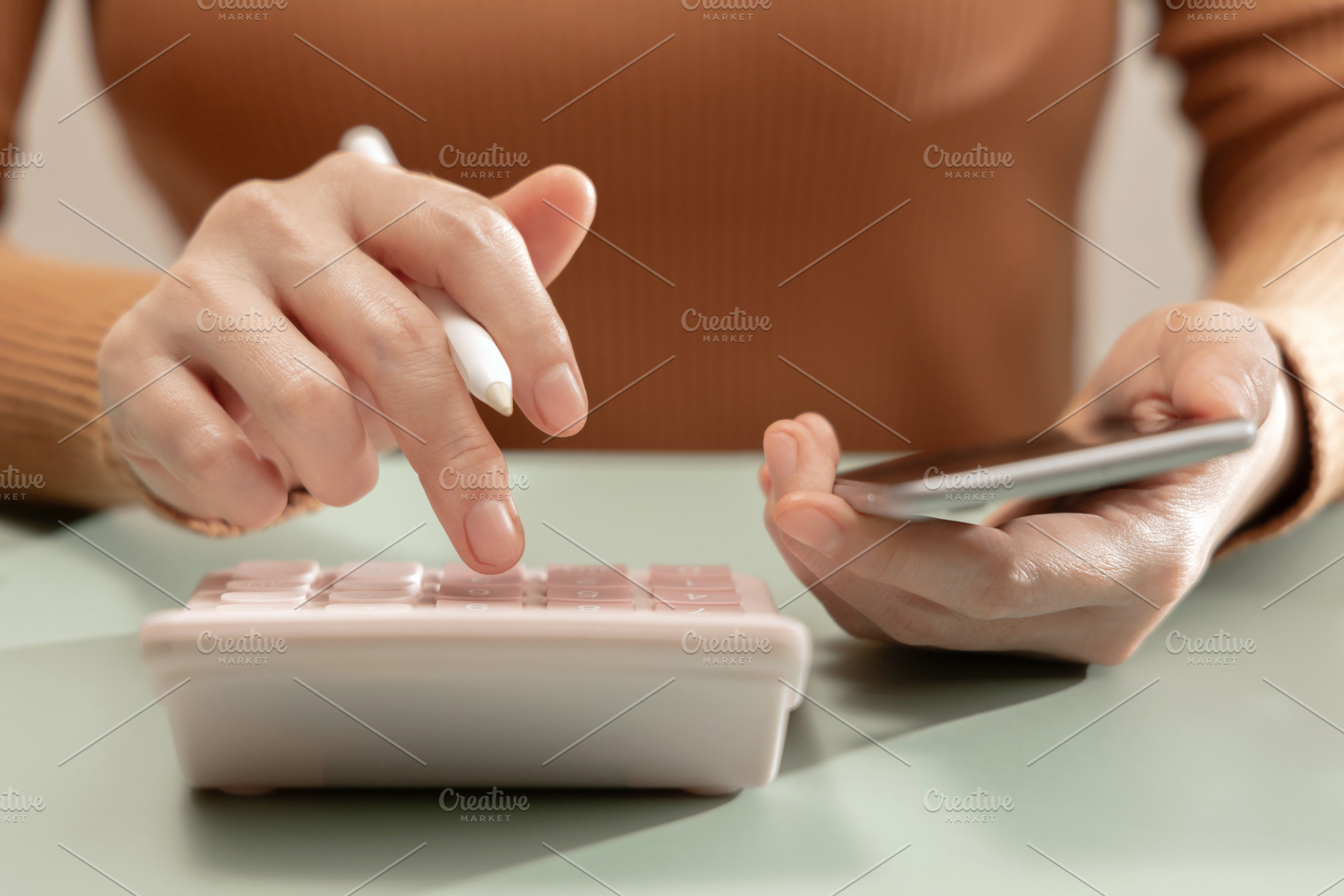 Woman using calculator and smartphone at desk. Personal finance, a Photo by salmon.black