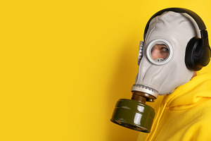 Close-up of person wearing a gas mask and black headphones, dres, a Person Photo by Ales Munt