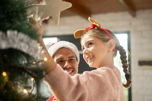 Father and daughter decorating Christmas tree together, a Person Photo by etorres69