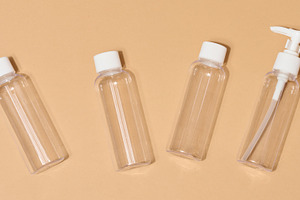 Travel set of plastic bottles for cosmetics on beige background, a Health & Medical Photo by ndanko