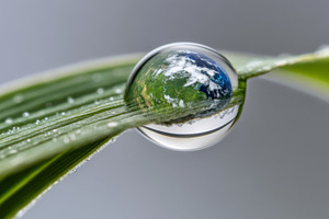 Earth Day concept with globe in Water droplet reflecting sky and, a Photo by Dvoevnore photos