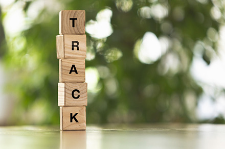 Five wooden cubes, blocks standing on table and showing word TRACK. Conceptual, a Business Photo by Volodymyr Melnyk