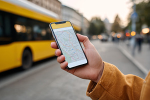 A young adult male, of Asian descent, navigates a city using a smartphone map w, a Business Photo by ImageMir