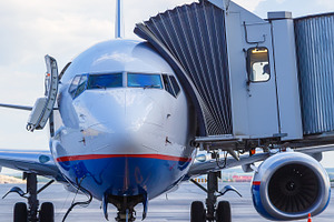 Commercial airplane parked at the airport featuring business, person, and