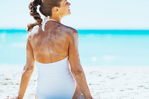 Young woman sitting on beach. rear view, a Person Photo by Alliance Images