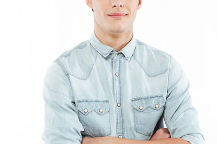 Young man standing with arms folded and looking at camera, a Person Photo by Dean Drobot