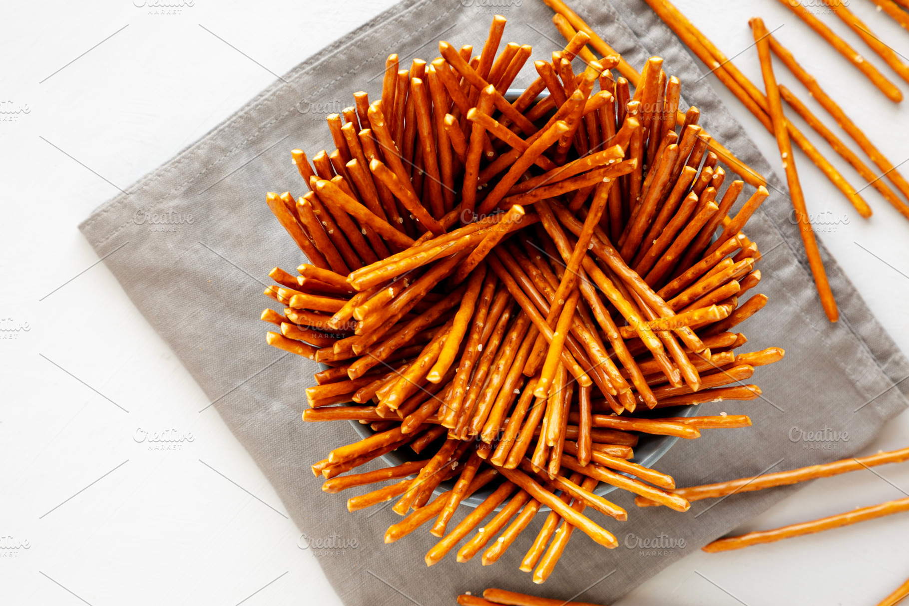 Organic Salty Pretzel Sticks in a Bowl, top view. Space for text, a Food & Drink Photo by LiudmylaChuhunova