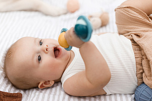 Beautiful happy baby lying on blanket and playing with toys on b, a Person Photo by Sonjachni