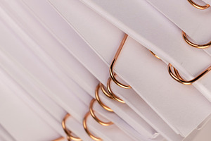 white blank sheets of paper connected by copper staples, a Photo by rsoollAI