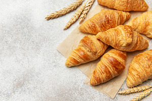 Freshly baked croissants with wheat on baking paper, a Food & Drink Photo by Olena Rudo