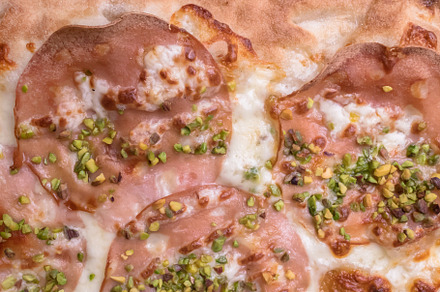 Pizza with ham and pistachios, a Background Photo by KYNA STUDIO