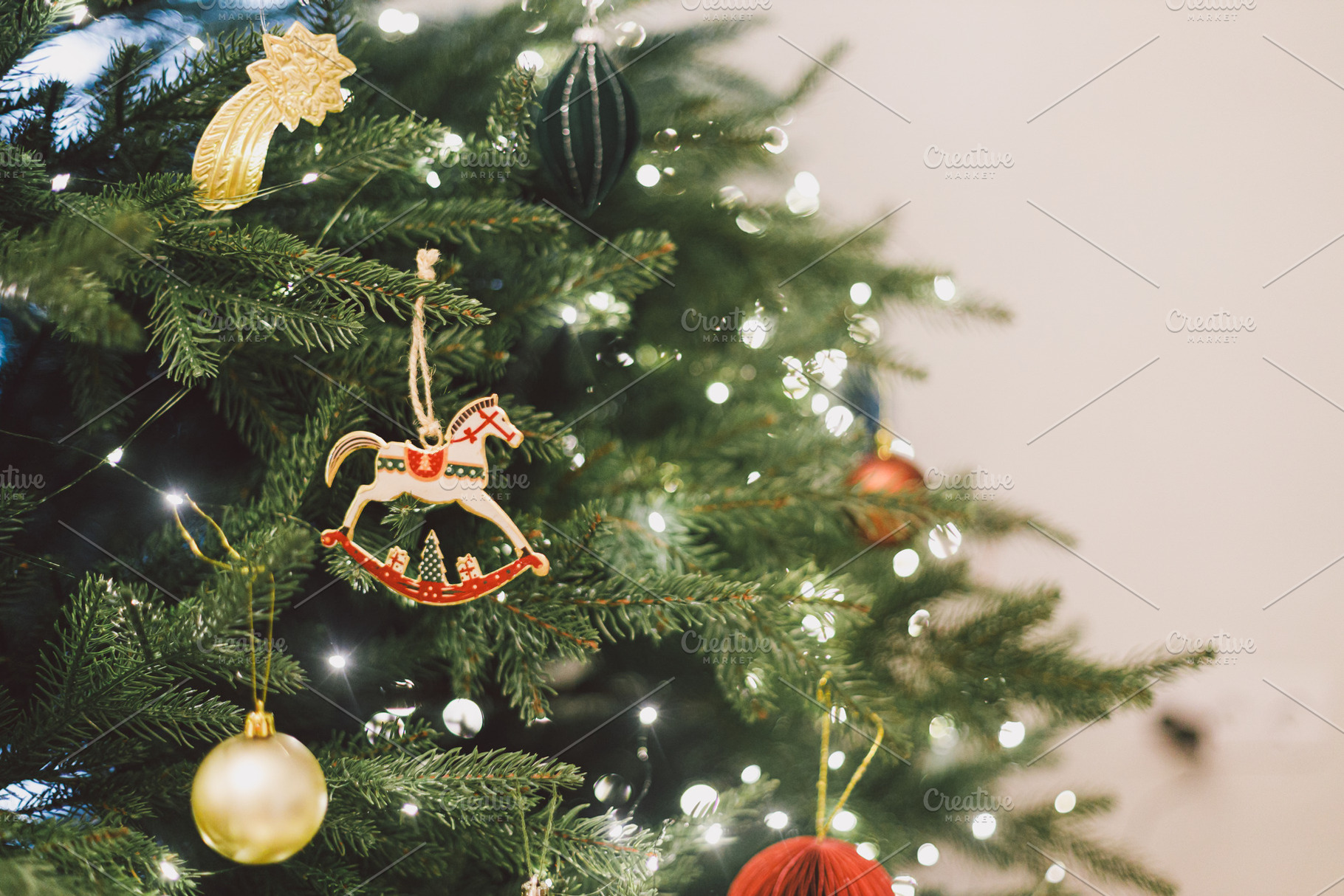 Stylish christmas horse toy hanging on xmas tree branch with fes, a Holiday Photo by Sonjachni