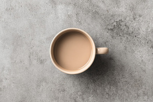 Beige ceramic mug on stone surface, a Food & Drink Photo by Virgo Studio
