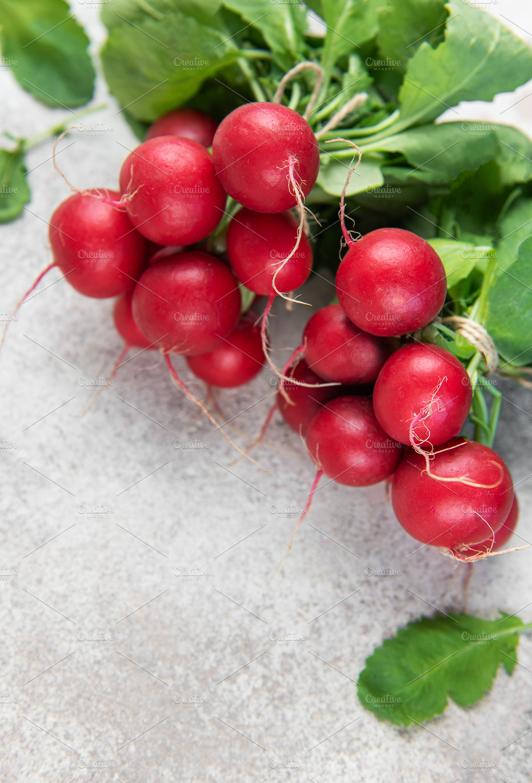 Fresh red radish bunch with green leaves on concrete, a Food & Drink Photo by Olena Rudo