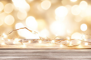 Festive bokeh lights on wooden table, a Photo by Dvoevnore photos