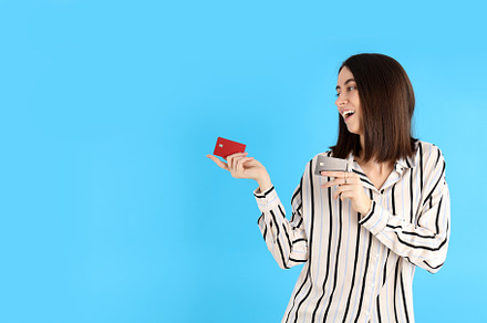 Attractive woman with cards on blue background, a Person Photo by AtlasStudio PRO