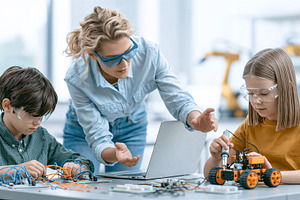 Teacher and children building robot, a School & Education Photo by 7DesignLab