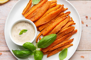 Sweet potato fries with dipping sauce and fresh basil, a Food & Drink Photo by Olena Rudo