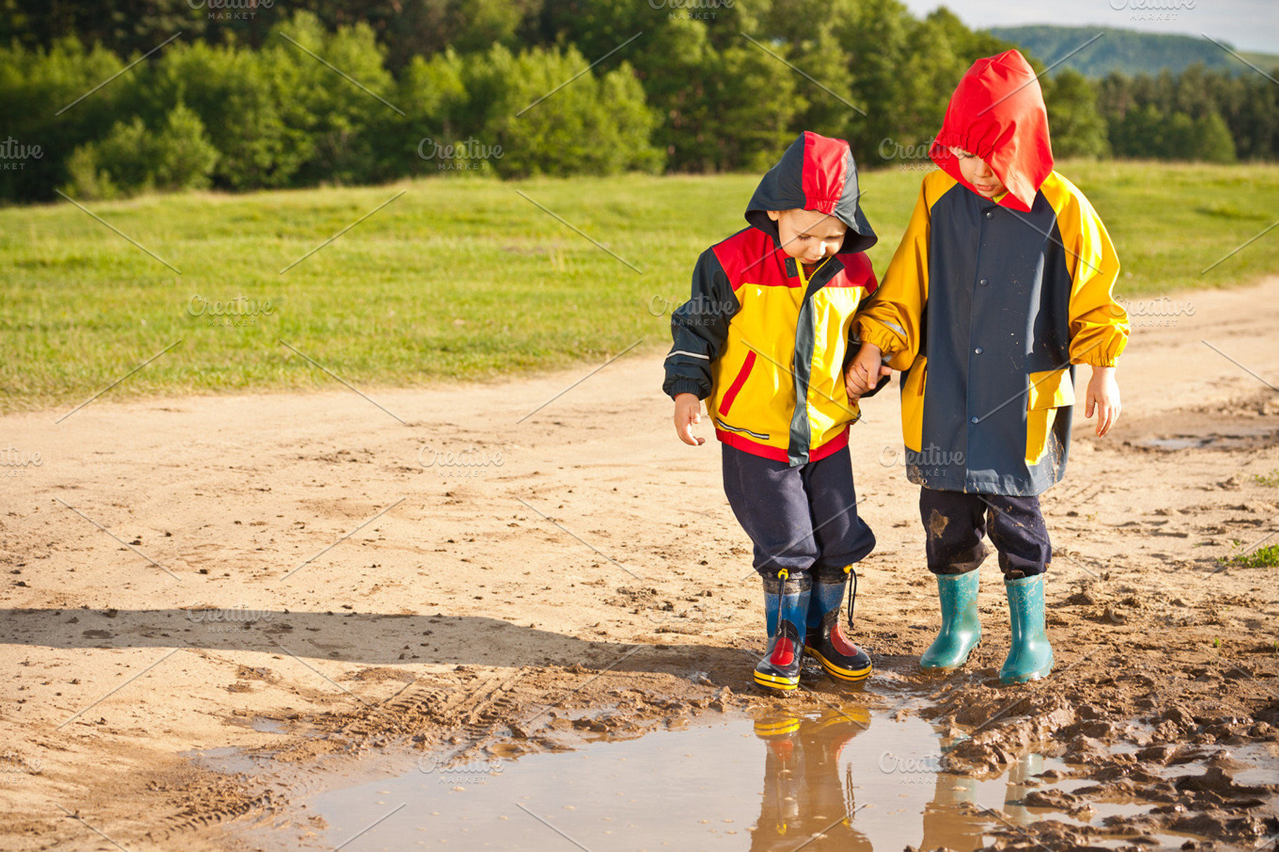 Two boys walking through a mud puddl