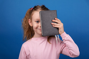Girl With Notebook on Blue Background, a Person Photo by Ales Munt